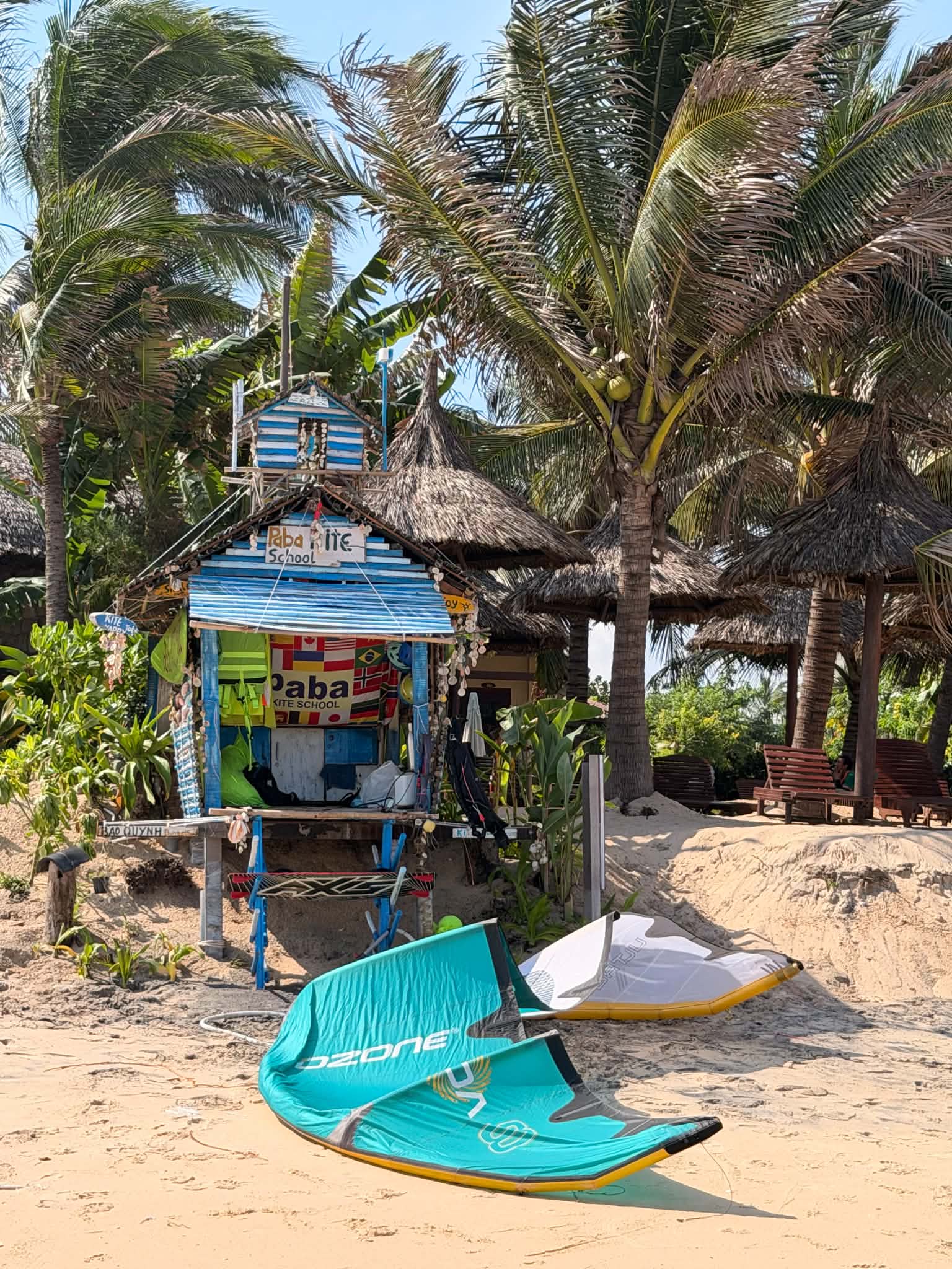 Paba Kite School beach base in Mui Ne with kites and palm trees